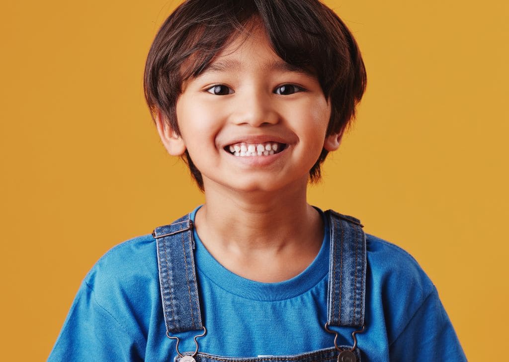 Braces for Kids in Malaysia - Costs, Types & When to Start 3 A child showing their teeth.