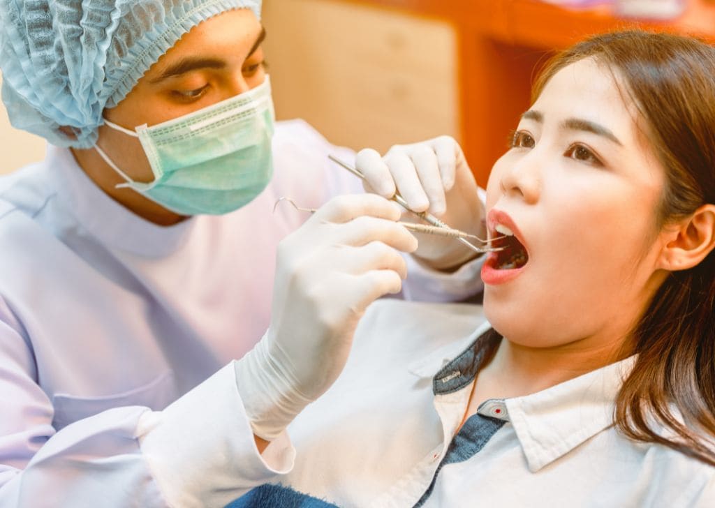 How Often Do Dental Fillings Need To Be Replaced? 5 Woman getting her teeth inspected at a dentist in Kepong.
