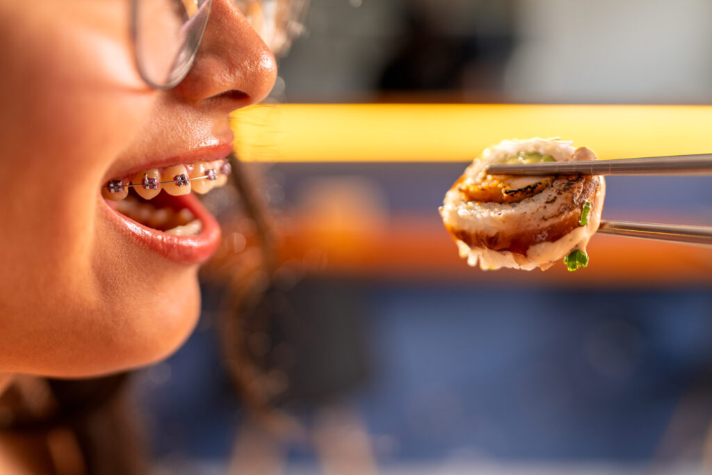 woman with braces enjoying sushi in restaurant ho 2025 04 29 03 37 58 utc
