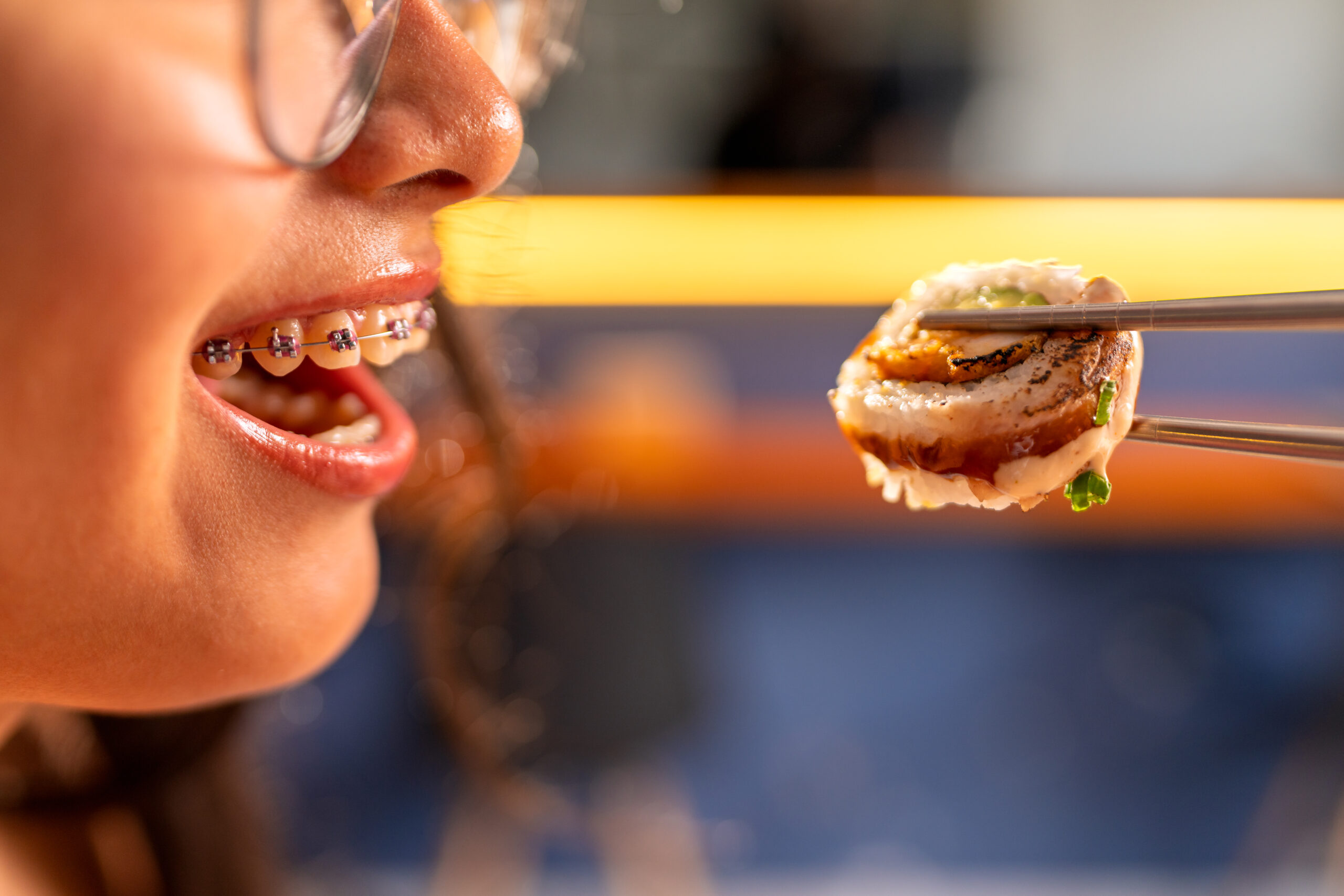 Brace Yourself: Foods to Avoid With Braces and Why 1 woman with braces enjoying sushi in restaurant ho 2025 04 29 03 37 58 utc scaled